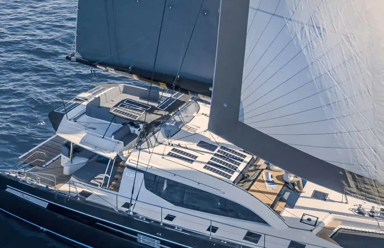 Luxurious yacht sailing on open sea with full sails and sleek design.
